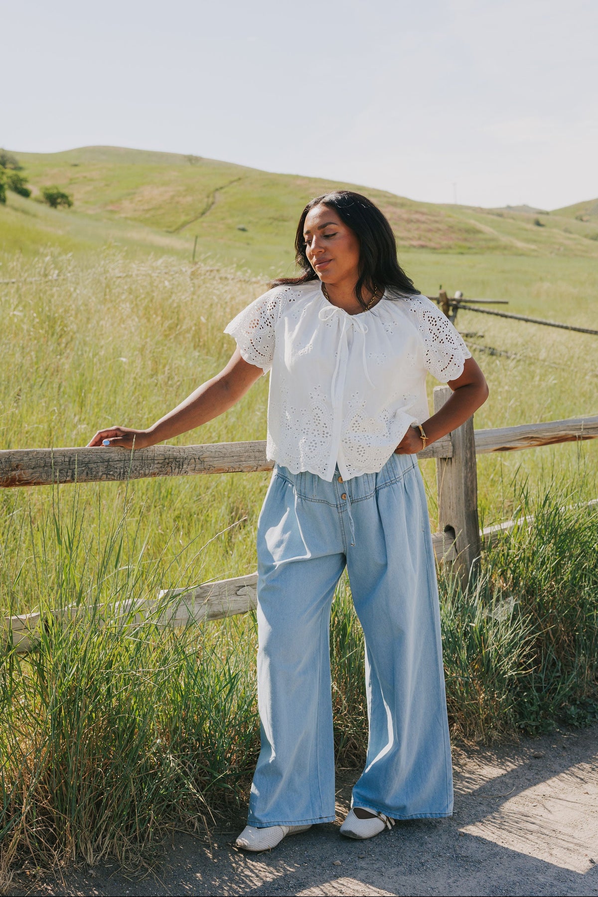 Light wash denim pants with pin-tucked and button details 