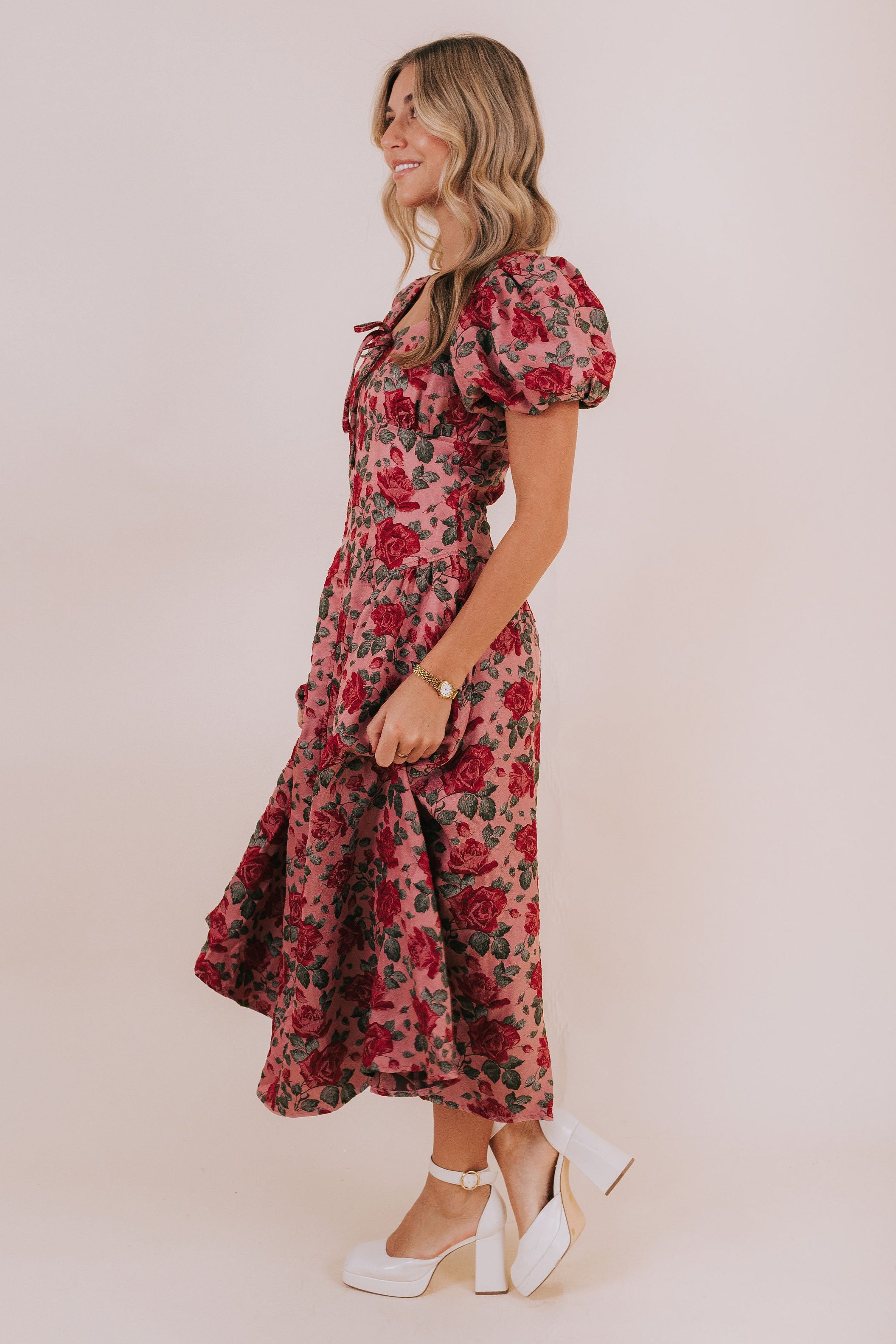 Rose colored midi or maxi length dress with red jacquard roses. Bow detail with short puff sleeves and square neckline. 