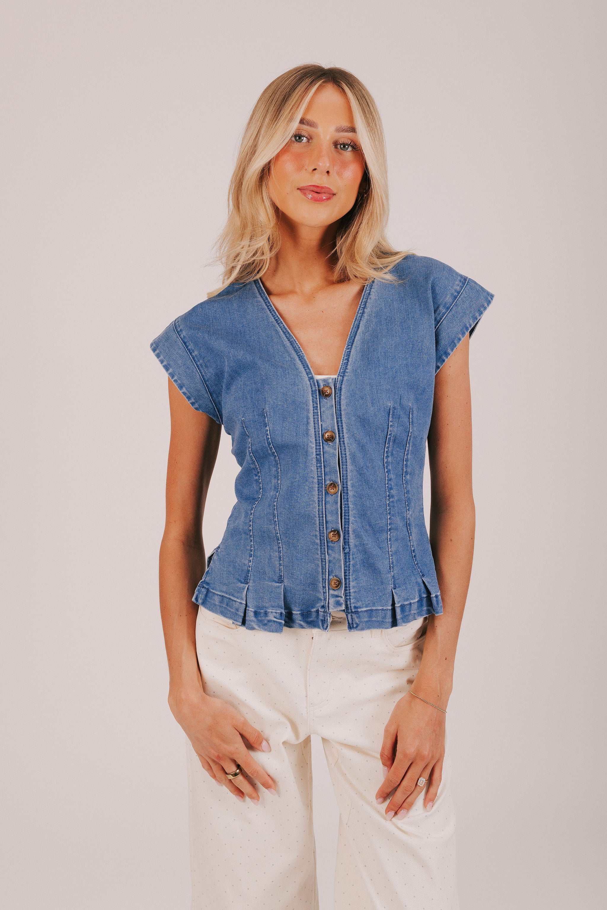 Button down denim shirt with cap sleeves and pleating. 