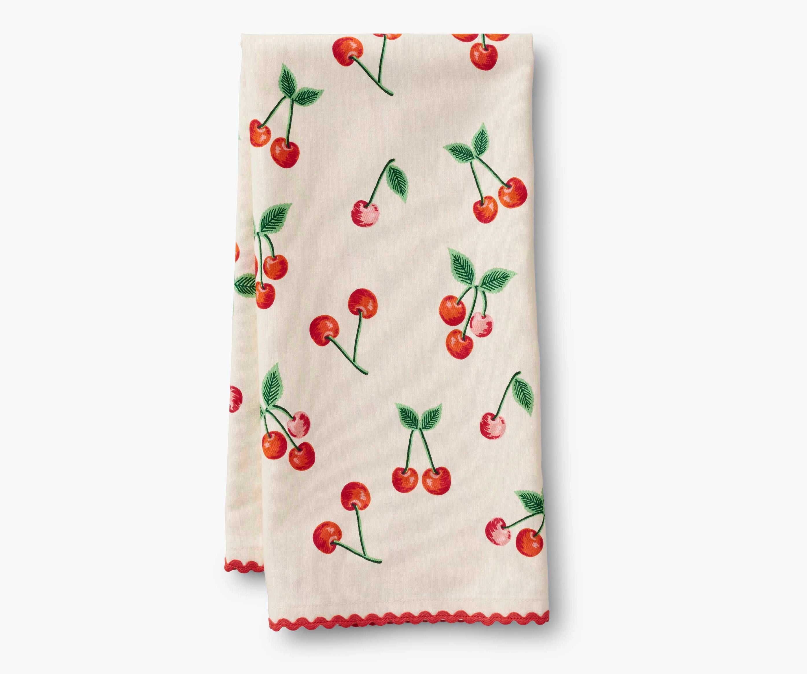 A cotton tea towel with a printed cherry pattern and red rick rack trim.