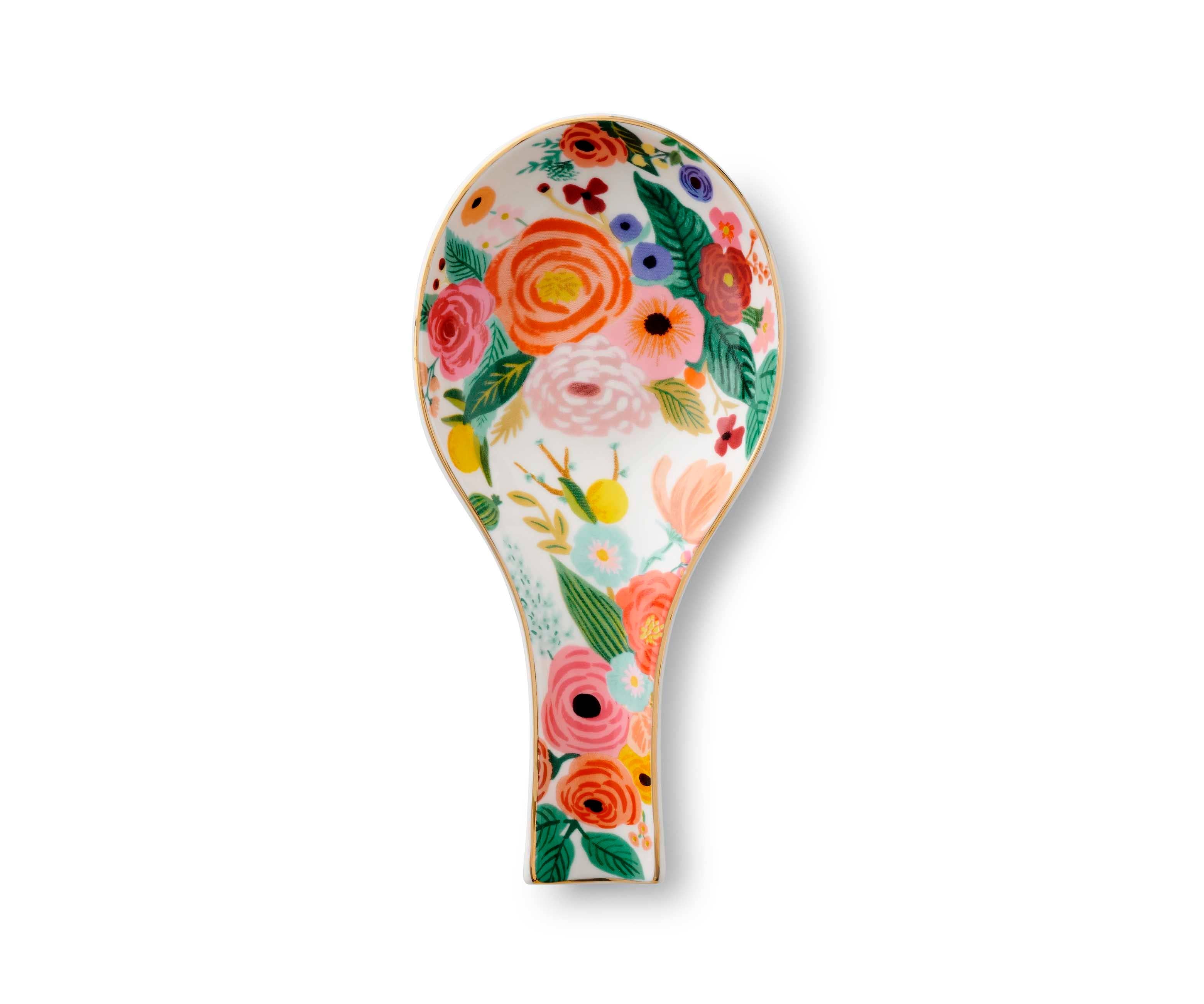 Floral patterned porcelain spoon rest with metallic gold edge.