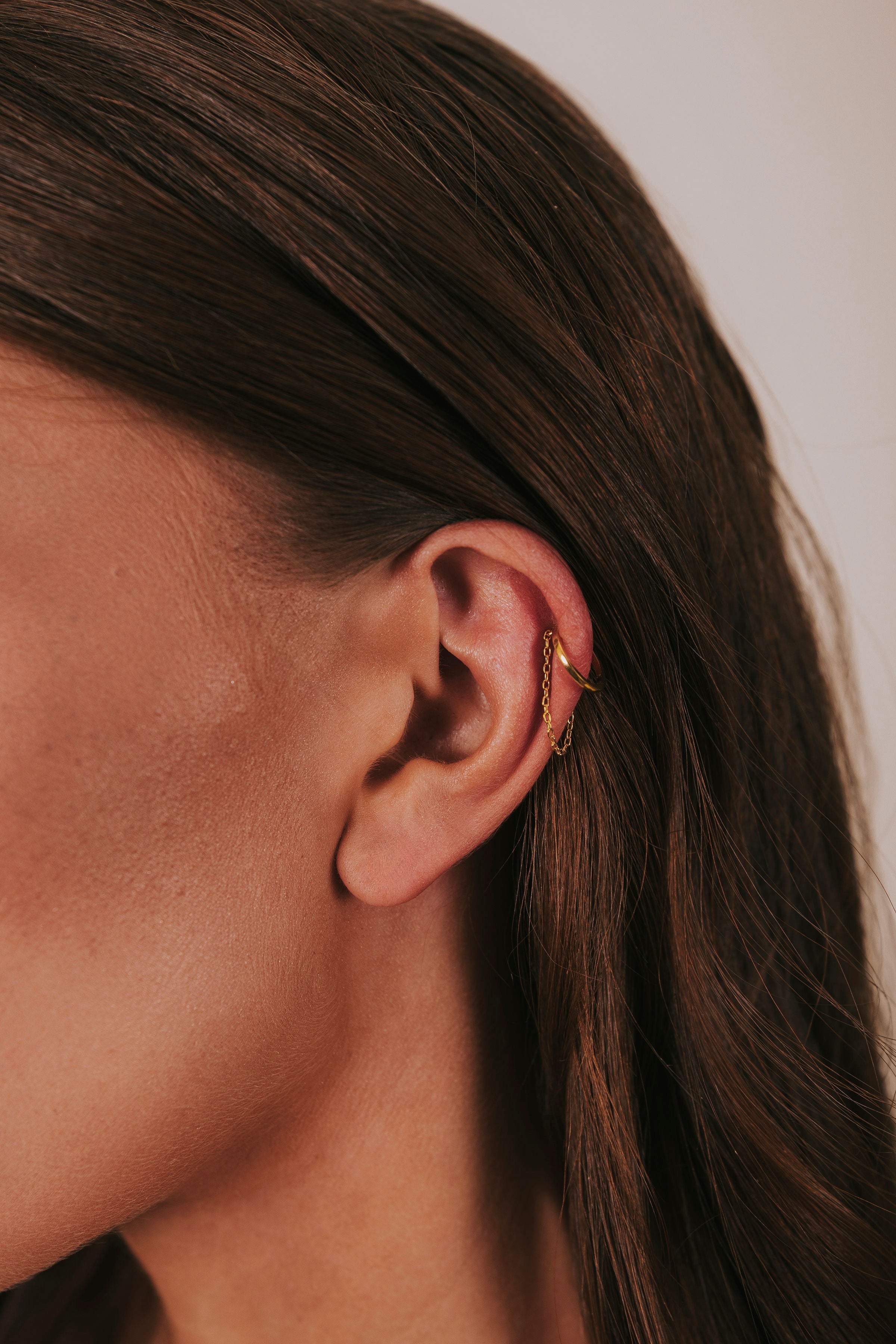 single ear cuff with dangling gold chain
