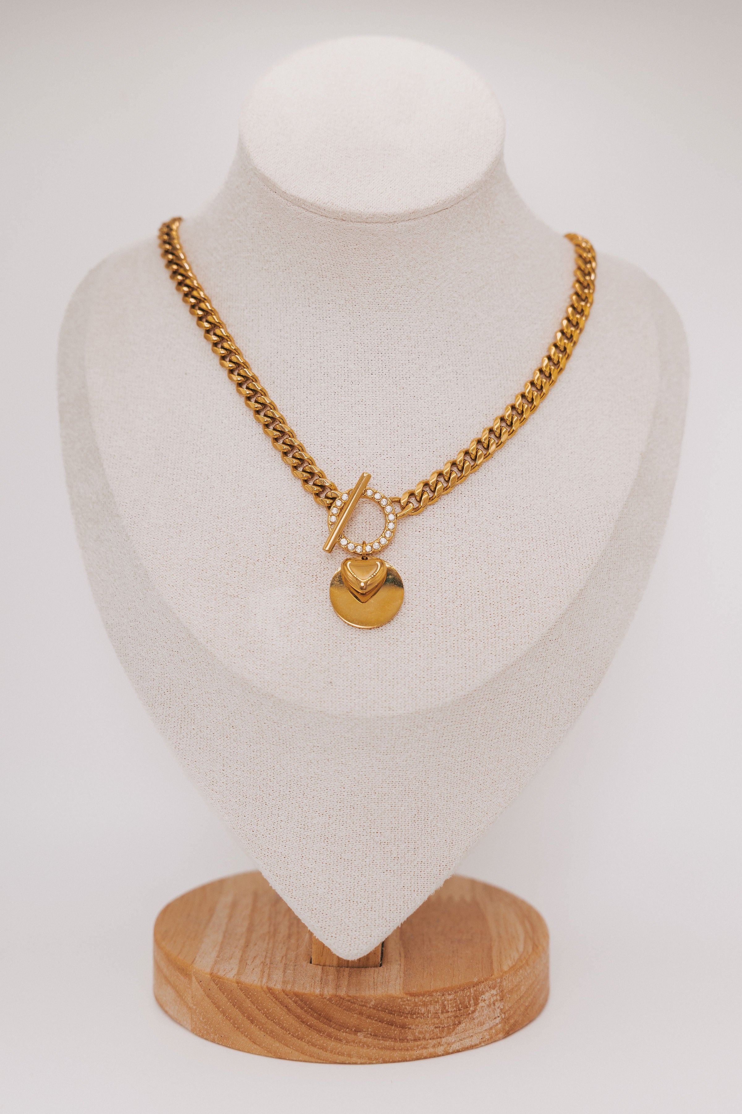 thick gold chain with stone accents and heart pendant