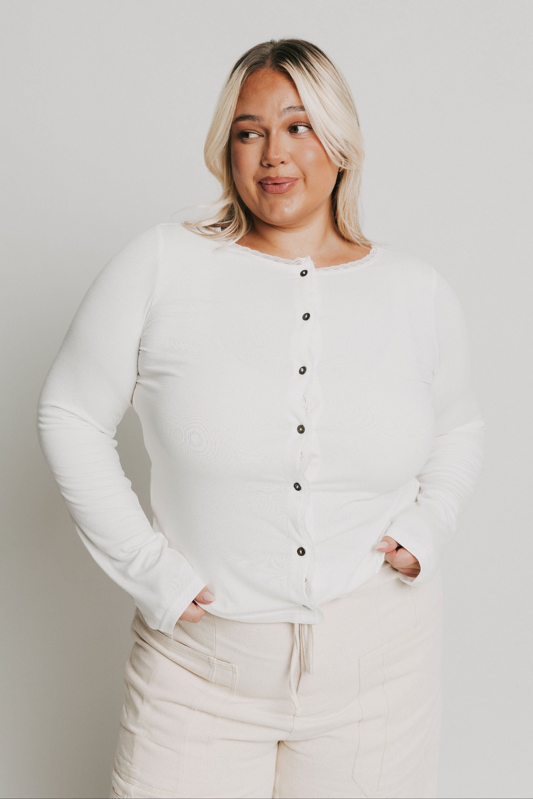 white long sleeve top with buttons and lace trim on neckline
