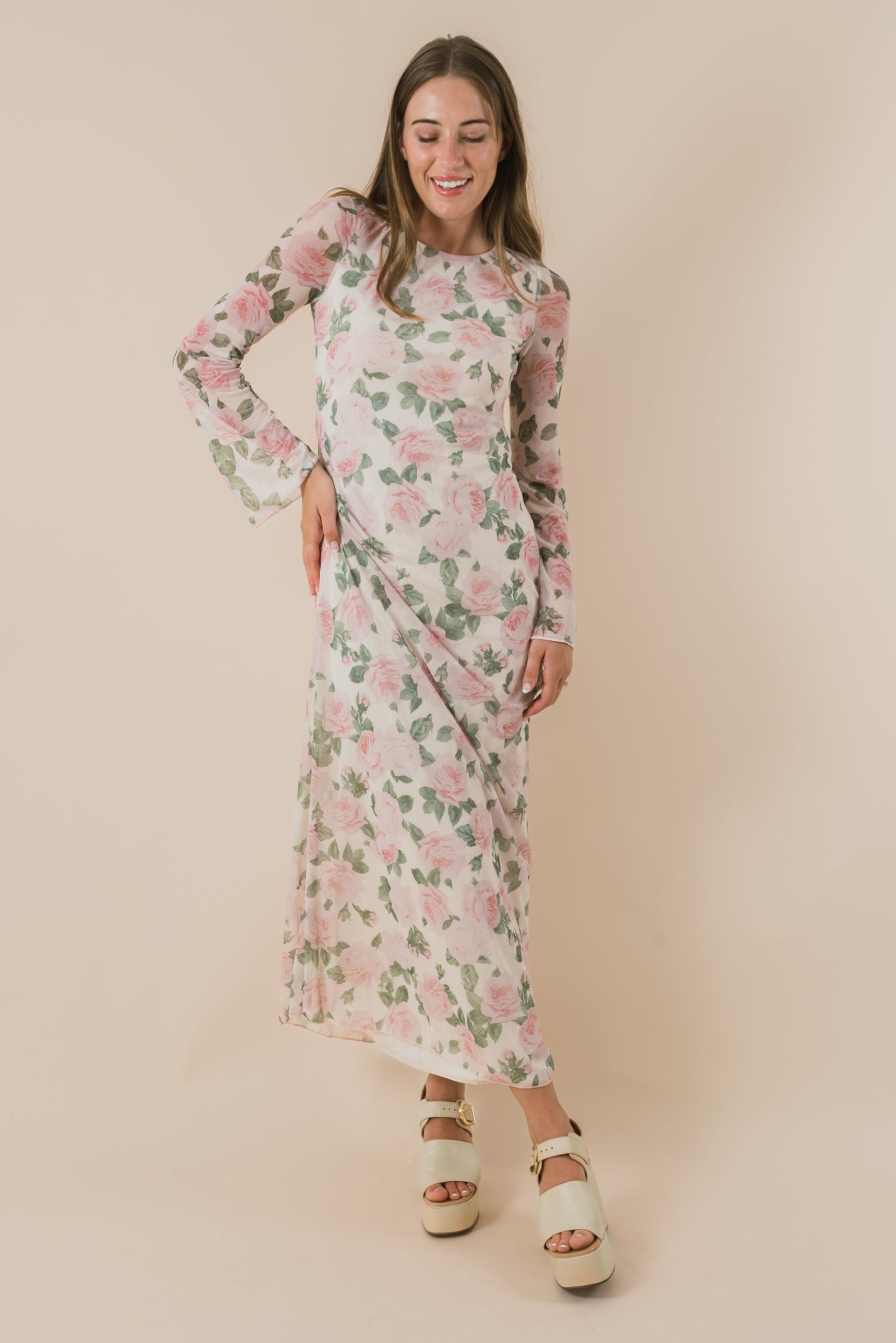 Woman wearing a floral dress against a beige background