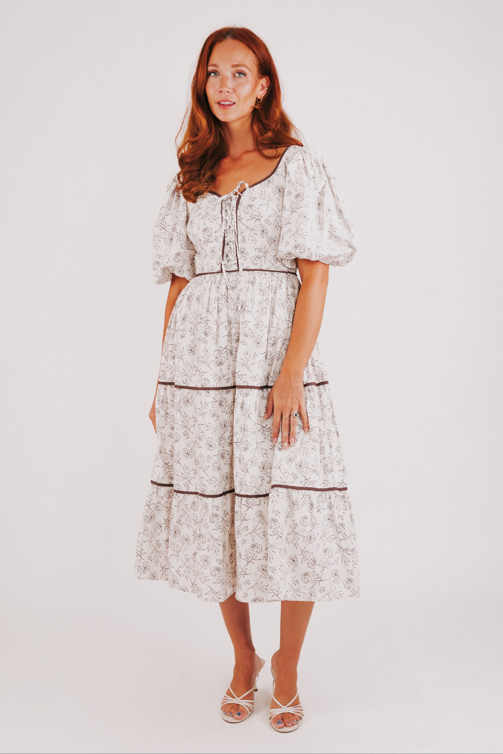 white tiered dress with brown floral pattern and puff sleeves