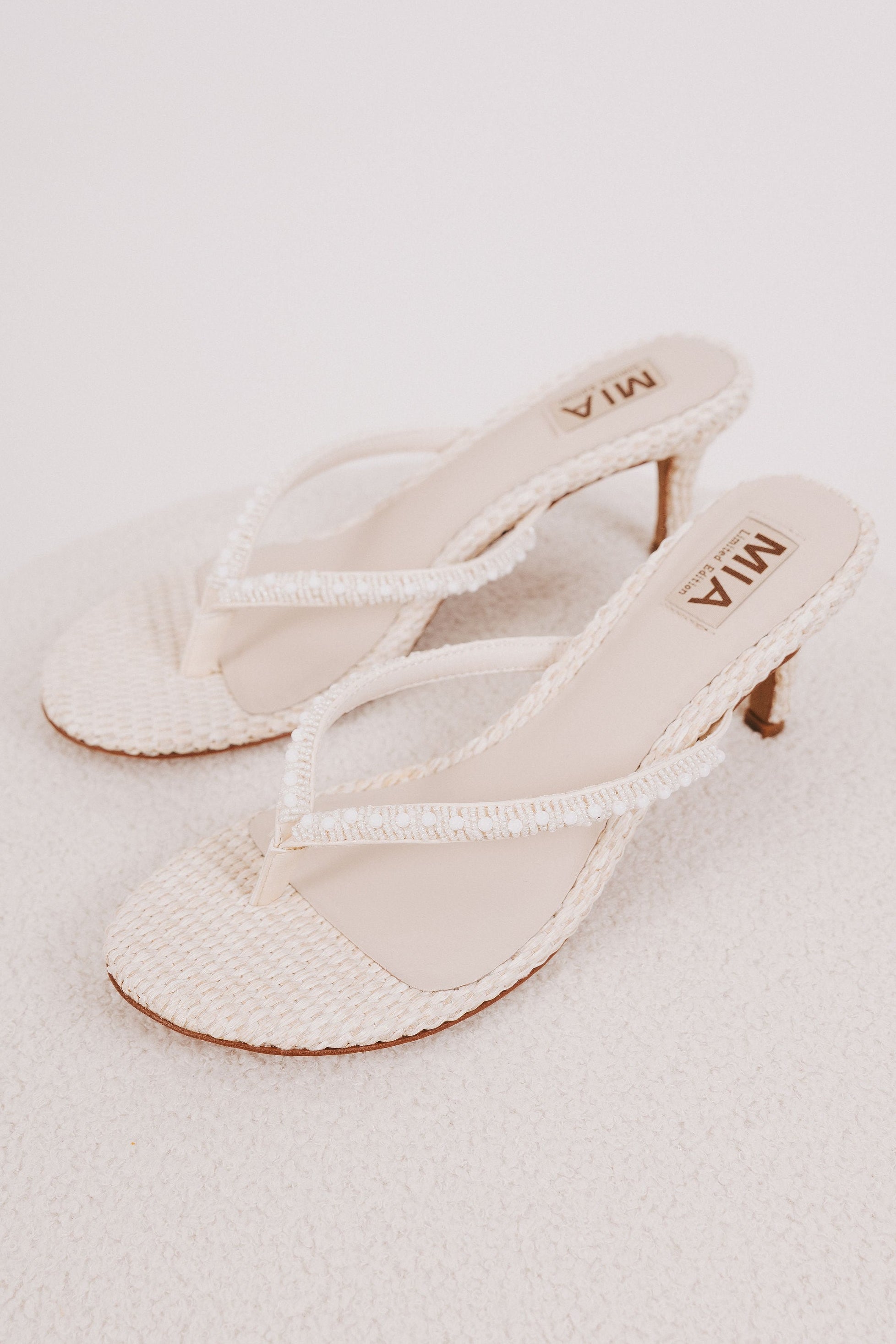 white woven heels with pearl detail