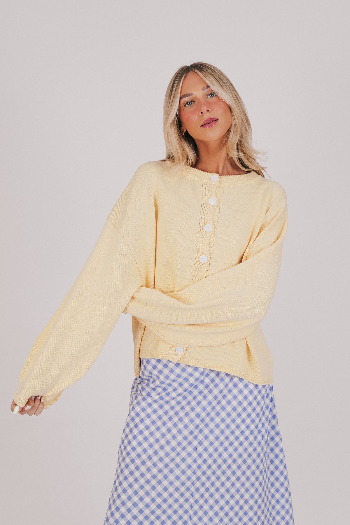 Light yellow sweater with a button down front and long sleeves 