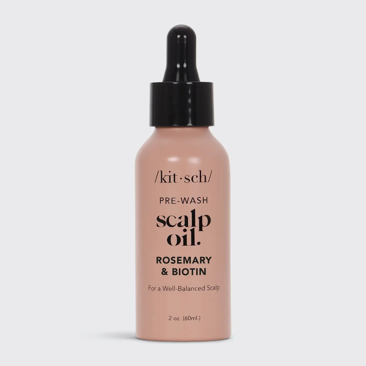 Bottle of scalp oil with dropper labeled 'kit sch' on a light gray background